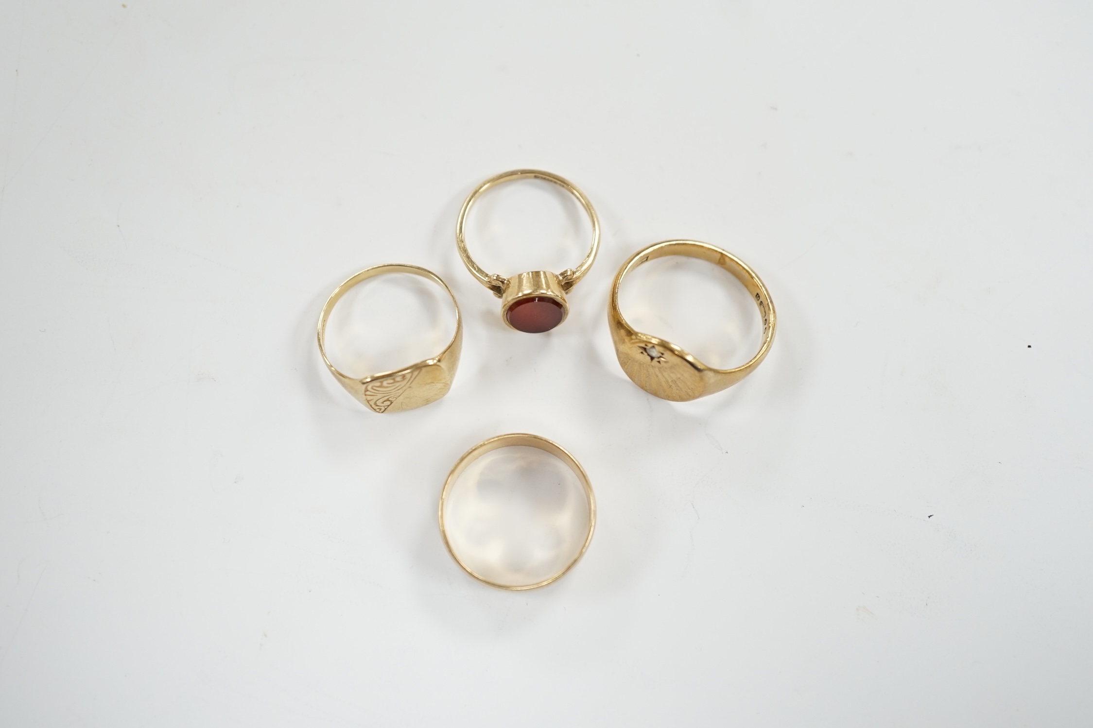 Four assorted 9ct gold rings including a wedding band and carnelian set, gross weight 13.6 grams.